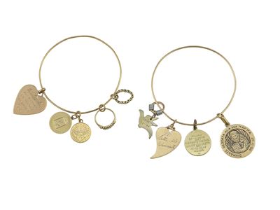 Lotto di gioielli in oro 750/1000, due bracciali con charms e spilla a mezza luna
