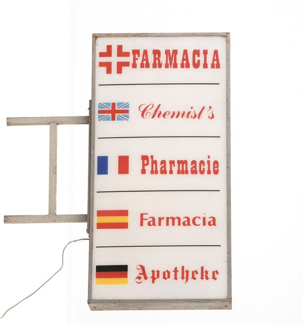Insegna luminosa farmacia bifacciale in diverse ingue.