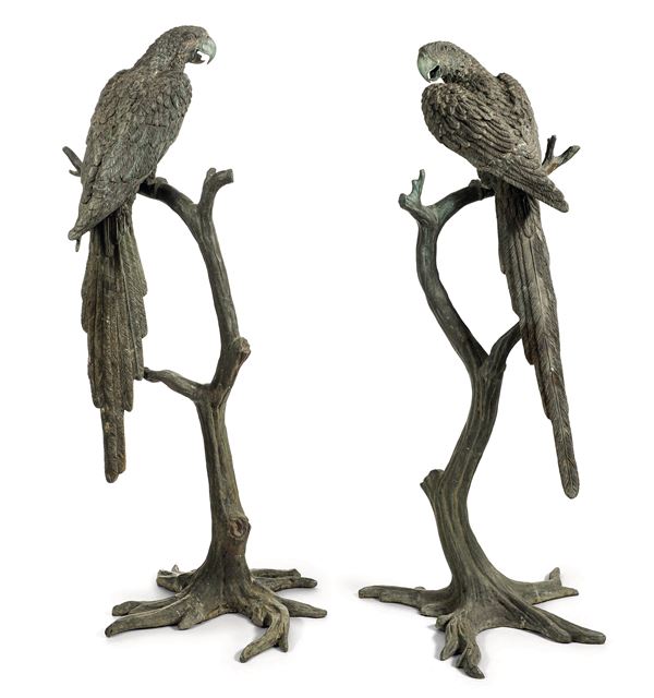 Coppia di sculture in metallo raffiguranti pappagalli su rami. XX secolo