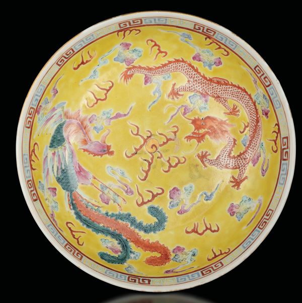 Piatto in porcellana a fondo giallo raffigurante drago e fenice, Cina, Dinastia Qing, probabilmente marca e del periodo Guangxu (1875-1908)