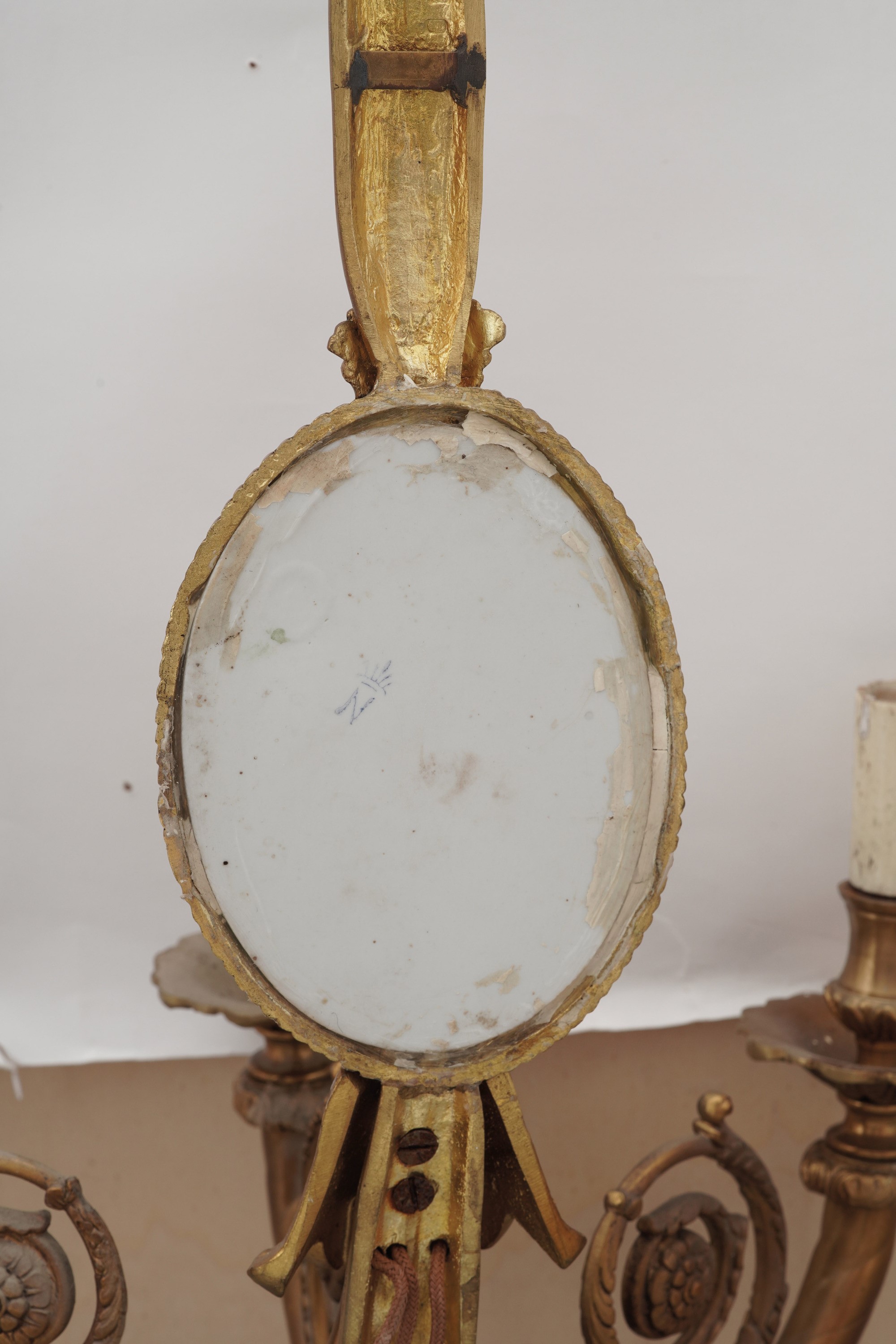 Coppia di appliques dorate a tre luci con placca floreale policroma in stile Capodimonte, XIX-XX ...
