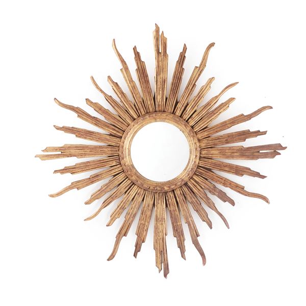 Specchiera circolare in legno intagliato e dorato a raggiera