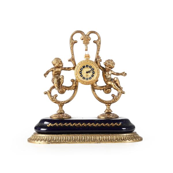 Orologio in metallo dorato e smalti. XX secolo