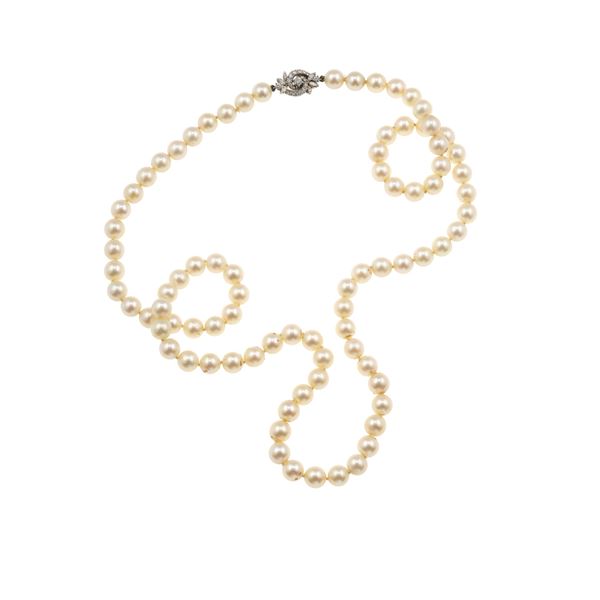 Long strand of cultured pearls with gold and diamond clasp