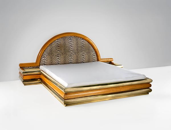 Letto con grande testiera e comodini integrati.