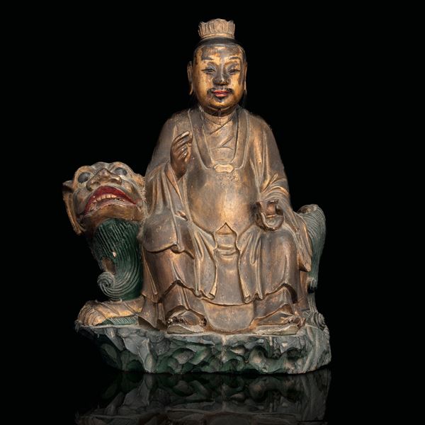 Figura in legno dorato raffigurante dignitario con Cane di Pho, tracce di policromia, Cina, Dinastia Qing (1644-1912)