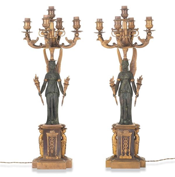 Coppia di candelabri di gusto impero in metallo dorato e patinato. XIX-XX secolo
