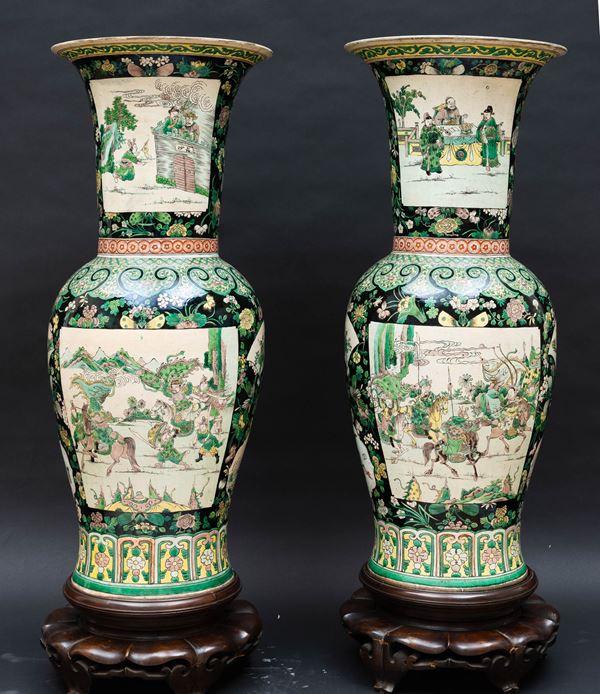 Coppia di grandi vasi in porcellana Famiglia Nera raffiguranti scena del “Romanzo dei Tre Regni”, figure con espressioni vivide, finemente dipinte in smalti colorati su uno sfondo nero e suggestivo. Completi di due basi in legno, sulla base reca il marchio apocrifo inciso a sei caratteri dell’Imperatore Kangxi, Cina, Dinastia Qing, epoca Guangxu (1875-1908)