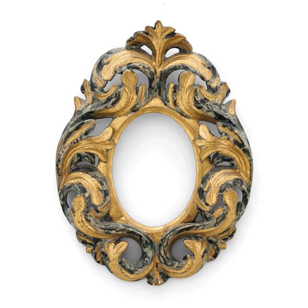 Cornice ovale in legno intagliato, dipinto e dorato. XVIII secolo