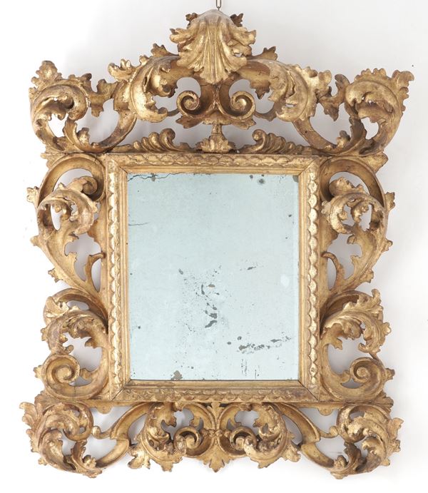 Piccola specchiera a cartoccio in legno intagliato e dorato. XIX-XX secolo