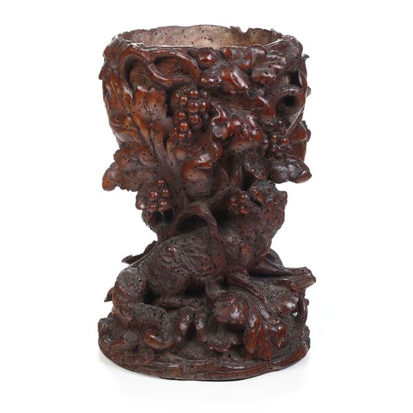 Vaso in legno intagliato con vite e uva.