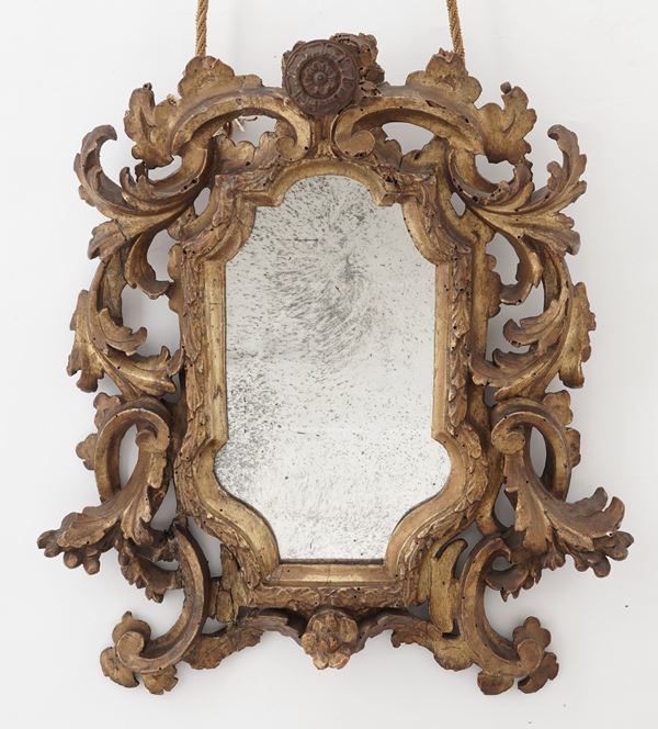 Specchiera a cartoccio in legno intagliato e dorato. XVIII-XIX secolo