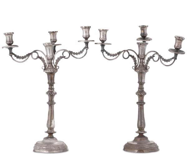 Coppia di candelieri in metallo argentato. XIX-XX secolo