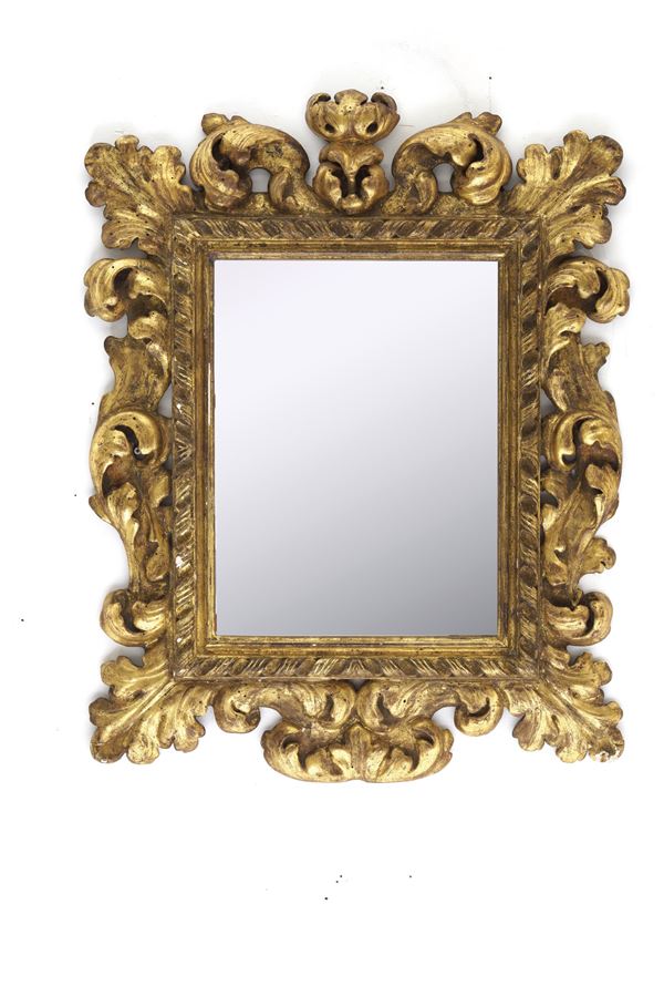 Cornice in legno riccamente intagliato a volute fogliate e dorato. XIX secolo