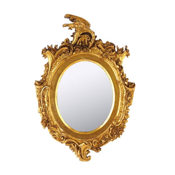 Cornice di forma ovale in legno intagliato e dorato. XIX secolo