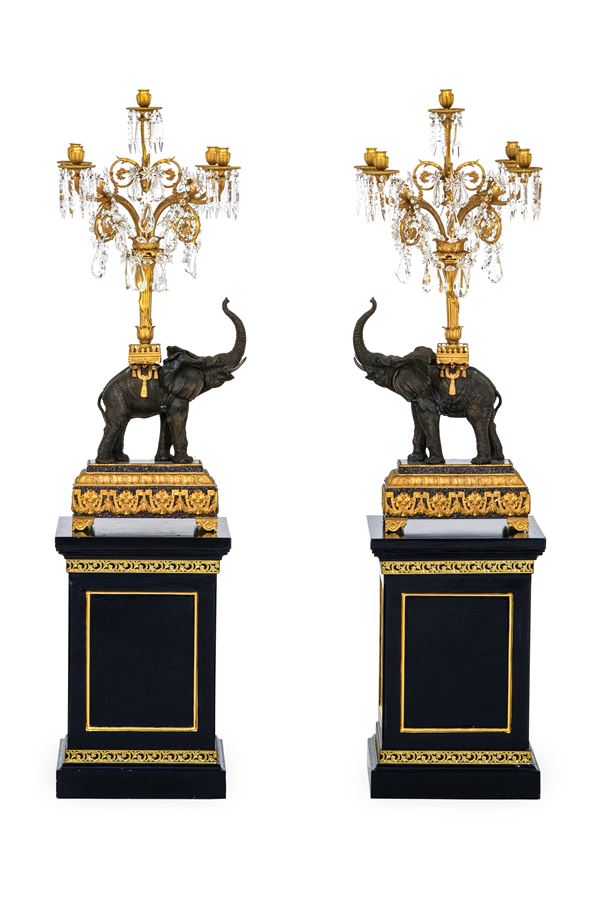 Coppia di grandi candelabri in bronzo patinato e dorato a guisa di elefanti. XX secolo