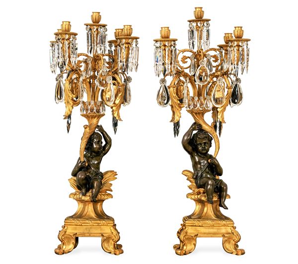 Coppia di candelabri a cinque luci in bronzo dorato e patinato. XX secolo