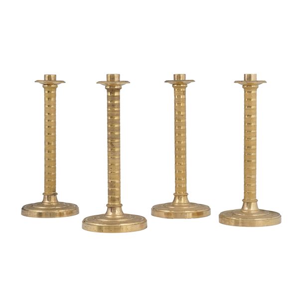 Quattro candelieri in bronzo fuso, dorato e cesellato. XIX secolo