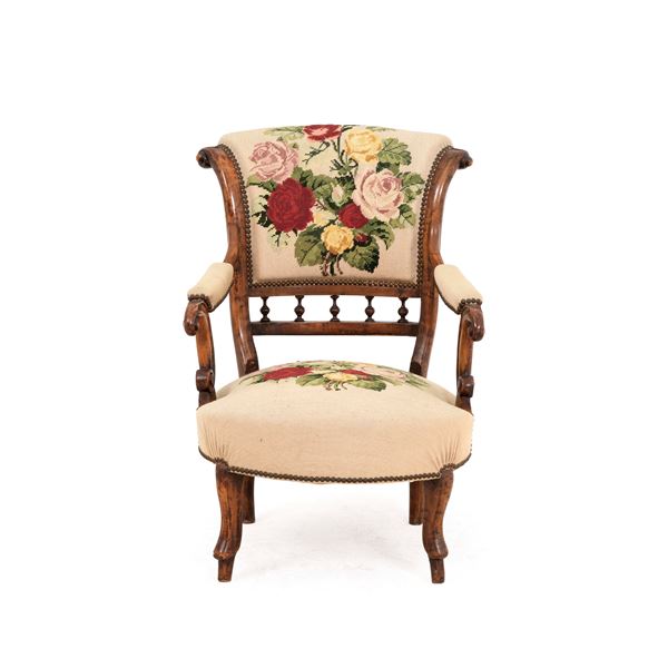 Poltrona in legno intagliato rivestita da tessuto a piccolo punto. XX secolo