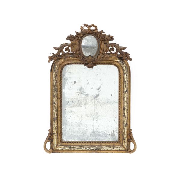 Specchiera in legno dorato con cimasa centrata da specchietto ovale Francia, stile Luigi XVI, XX secolo