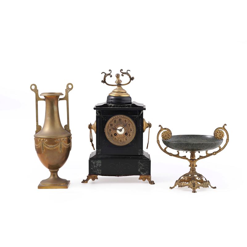 Lotto di una pendola da tavolo in marmo e metallo dorato, unita ad un vaso biansato in metallo dorato e una tazza in marmo verde montata in metallo dorato. Francia, XIX secolo  - Auction Antiques - Cambi Casa d'Aste