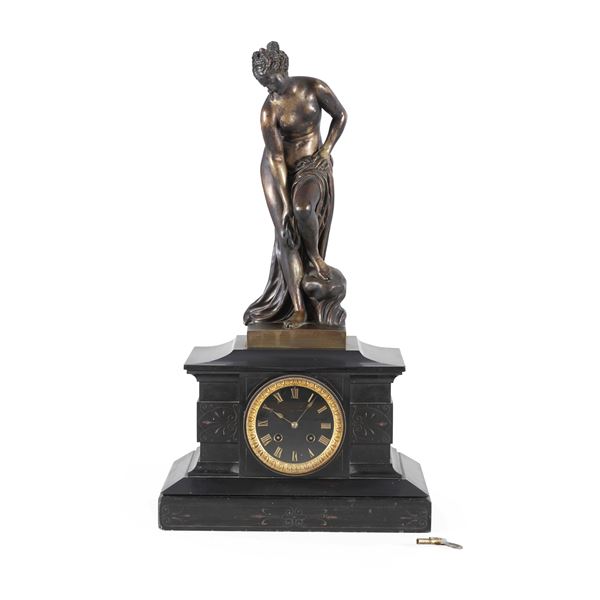 Orologio da appoggio con cassa in marmo nero sormontata da figura di Venere in bronzo. XX secolo