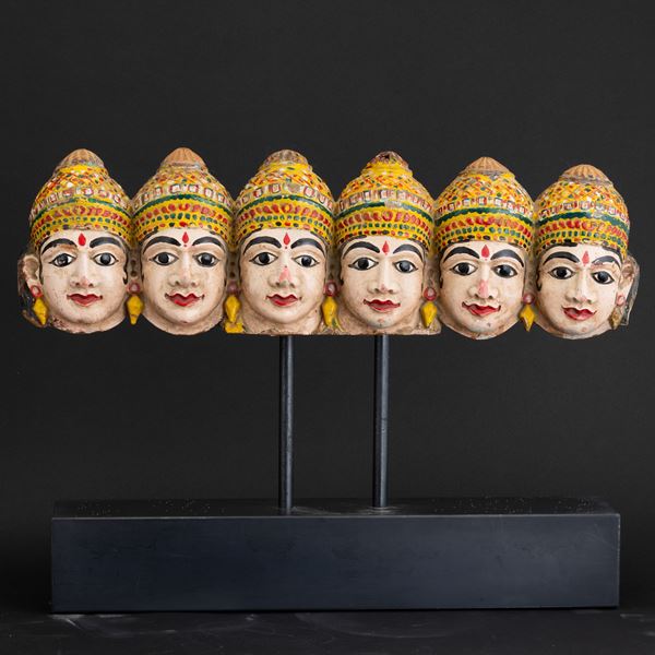 Gruppo di sette teste in legno scolpito e dipinto, India, XIX secolo