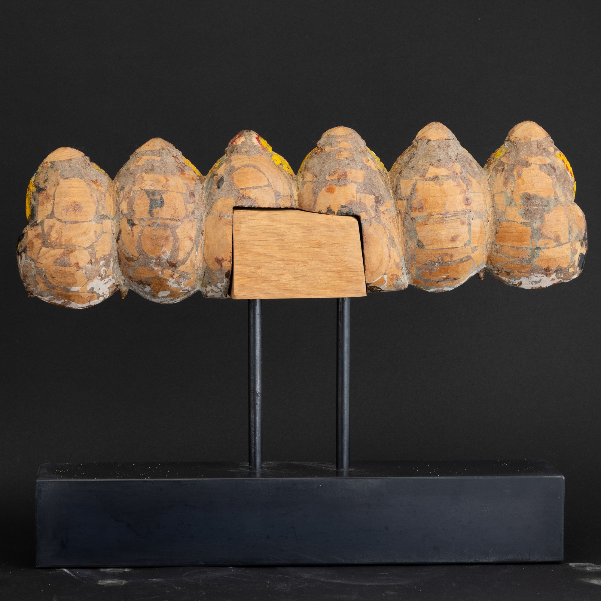 Gruppo di sette teste in legno scolpito e dipinto, India, XIX secolo
