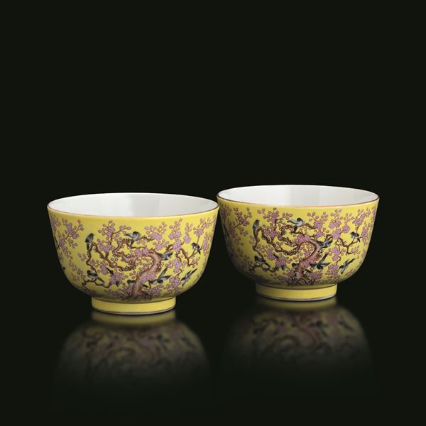 Pair of Famiglia Rosa porcelain bowls with yellow background depicting a landscape scene with birds and cherry trees, China, 20th century
