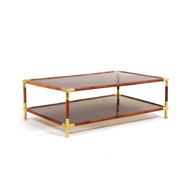 Tavolo a due ripiani in vetro con struttura in legno e applicazioni in metallo