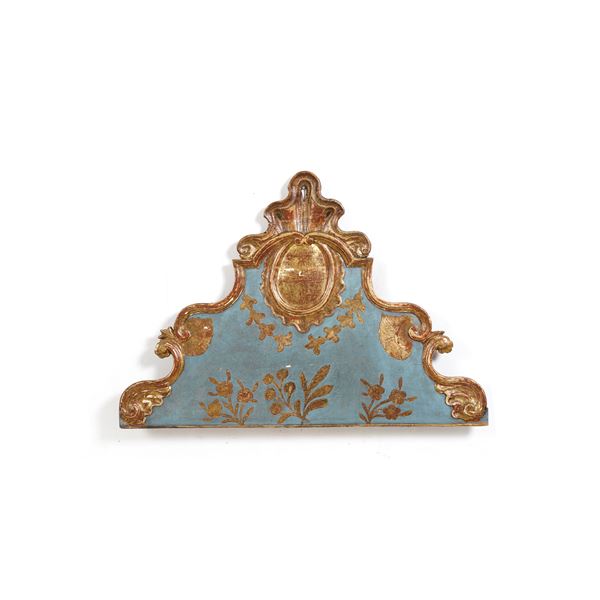 Testiera di letto in legno intagliato, dipinto e dorato.