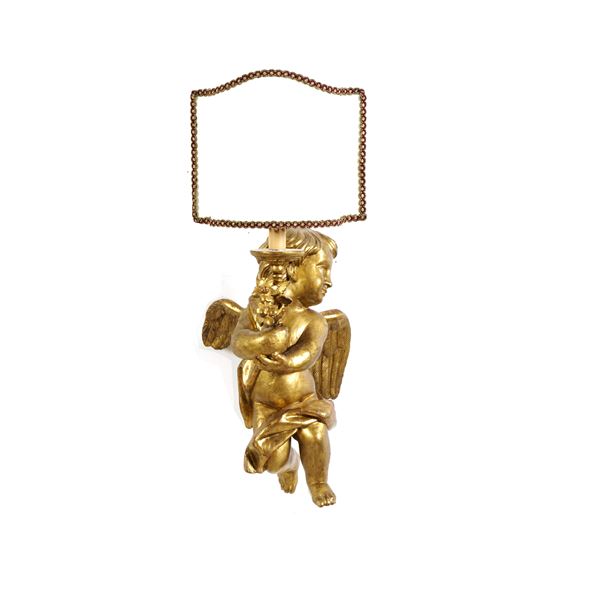 Applique in legno intagliato e dorato con putto. XIX secolo