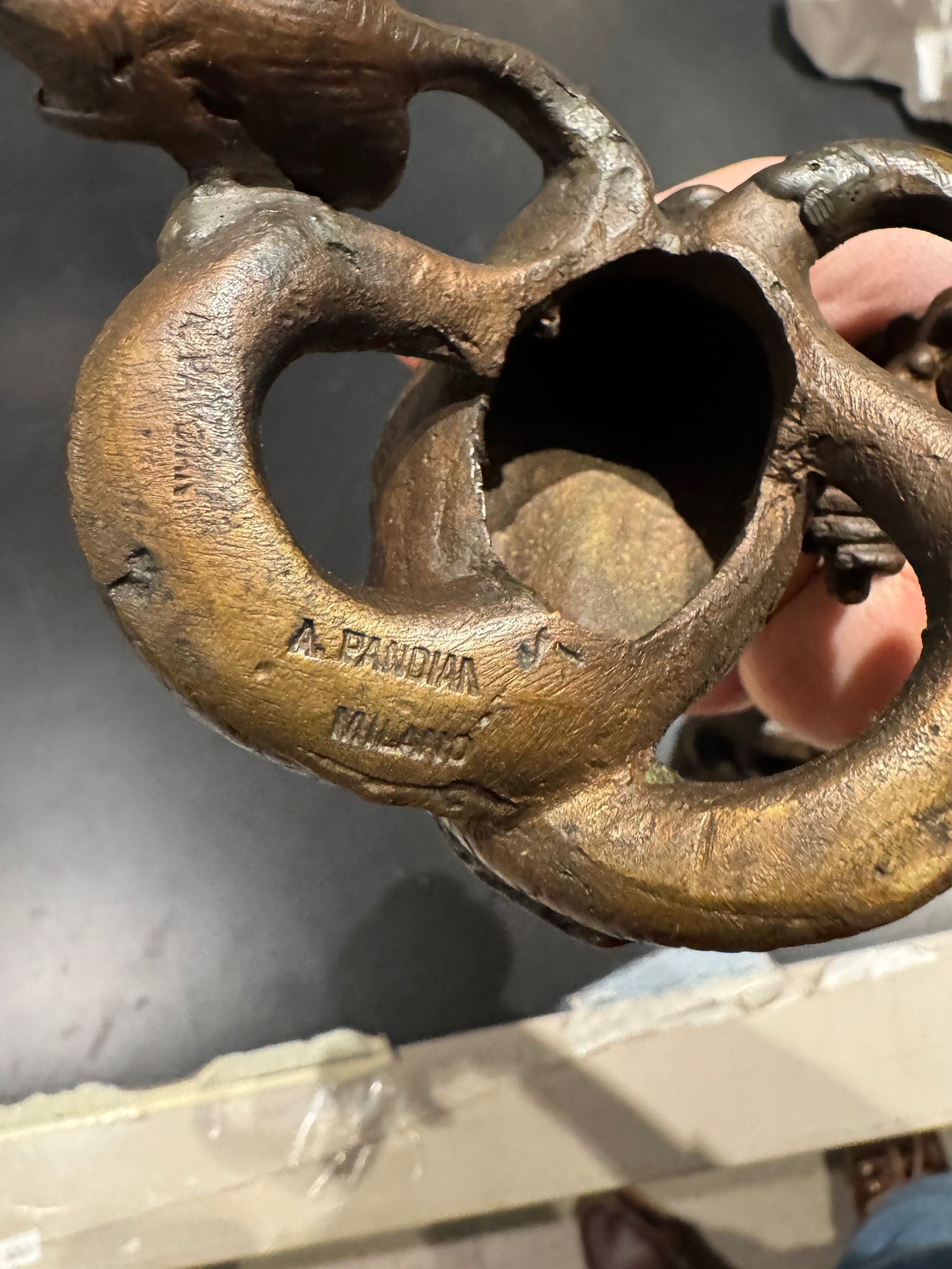 A. Pandiani Milano, Coppia di candelieri a foggia di tritoni, bronzo fuso e patinato