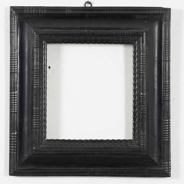 Cornice guilloché in in legno intagliato e laccato di nero