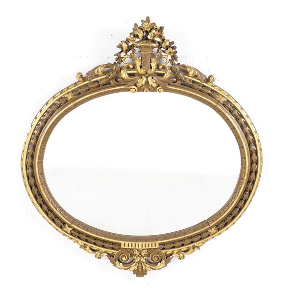Specchiera ovale in legno intagliato e dorato. XX secolo