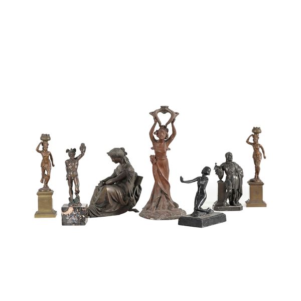 Cinque sculturine e una coppia di candelieri in metallo