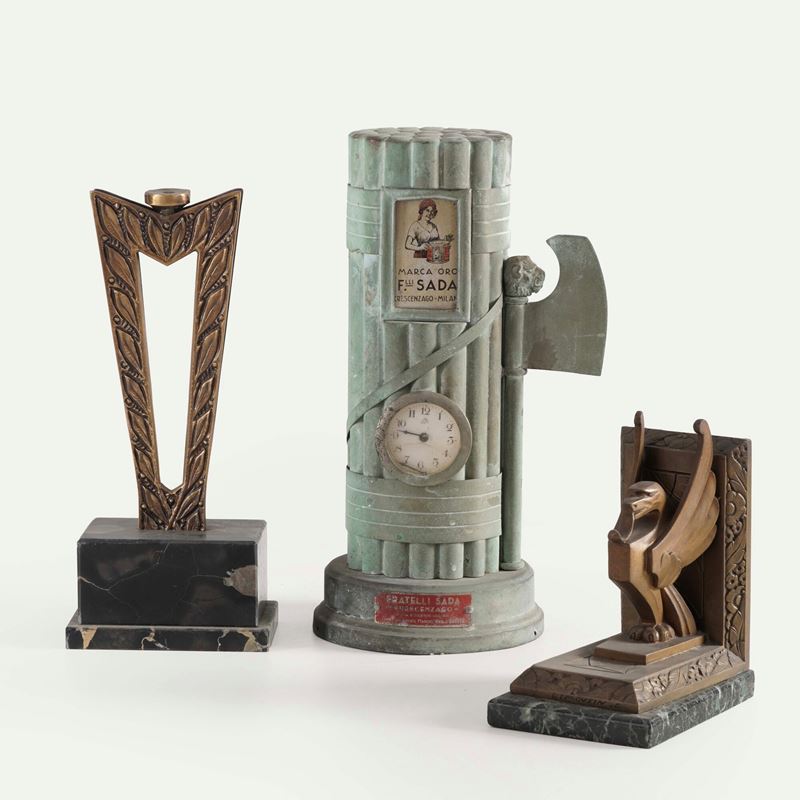 Un orologio da tavolo con cassa a foggia i fascio littorio e due trofei  - Auction Oggetti d'Arte - Ettore Mocchetti's Wunderkammer - Cambi Casa d'Aste
