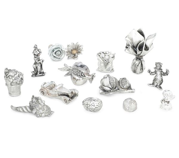 Lotto di oggetti in metallo e argento di varie forme tra cui melograni, una cornucopia, pagliacci ed altro