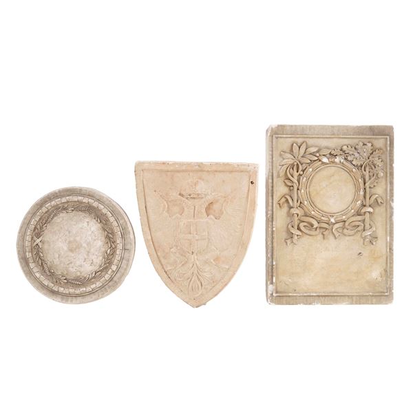 Due rilievi in gesso e uno stemma in terracotta