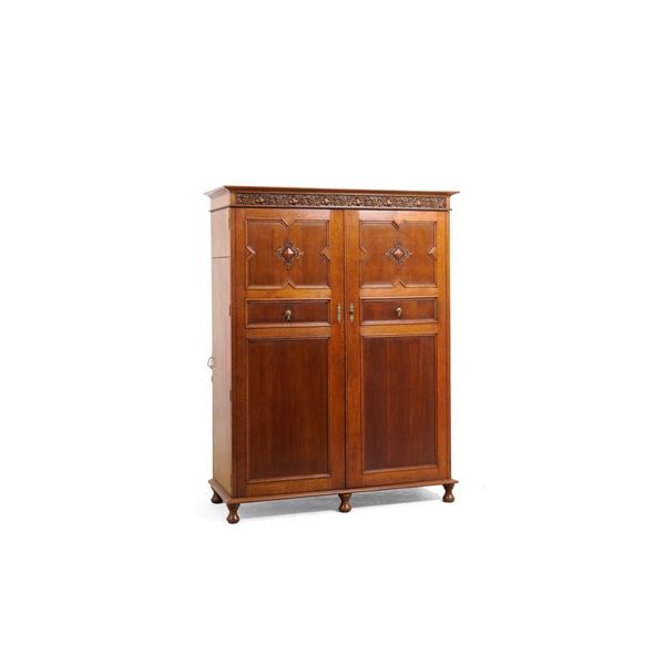 Armadio a due ante pannellate con cappello intagliato a tralci di vite. XX secolo