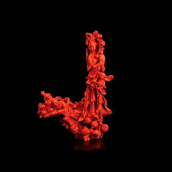 Figure carved in red coral depicting Guanyin holding a vase and flowers, accompanied by two maidens, China, Qing Dynasty, 19th century