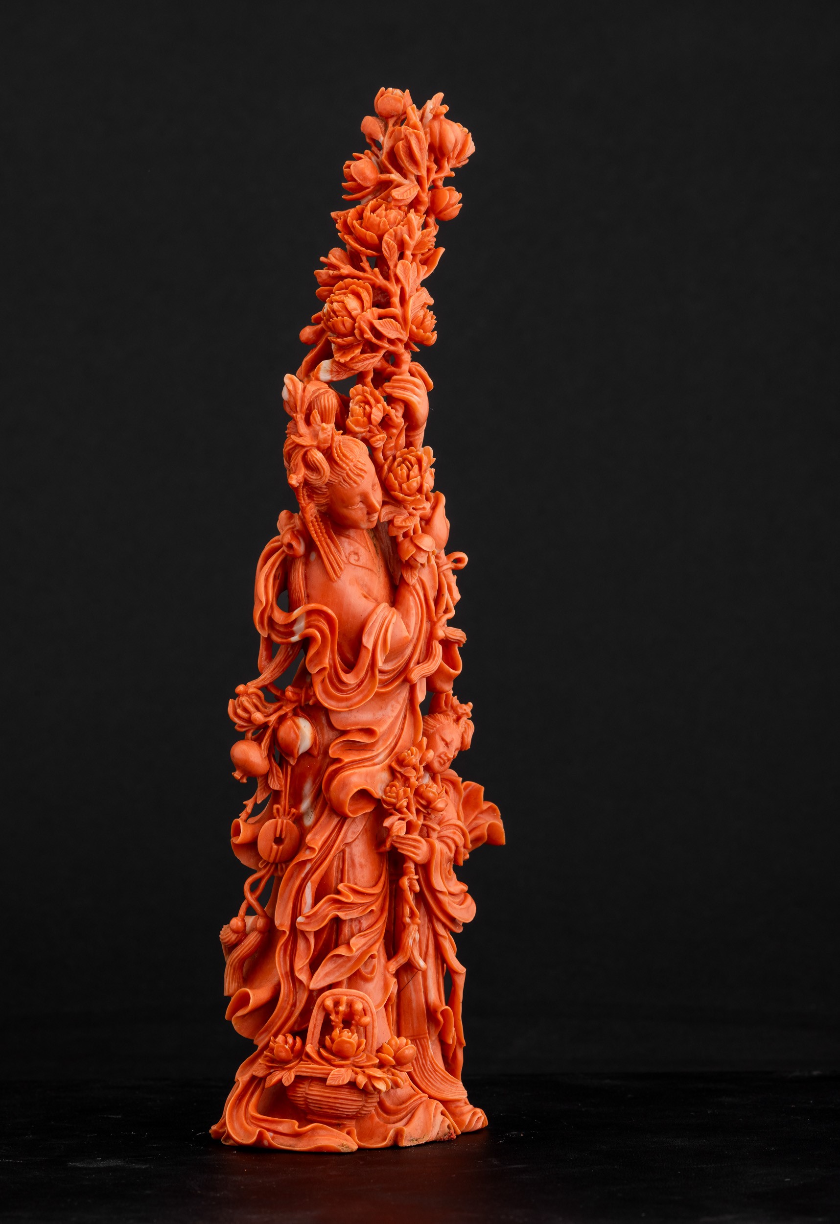 Cina, Dinastia Qing, Figura di Guanyin in corallo rosso con fiori tra le mani e fanciulla scolpit...