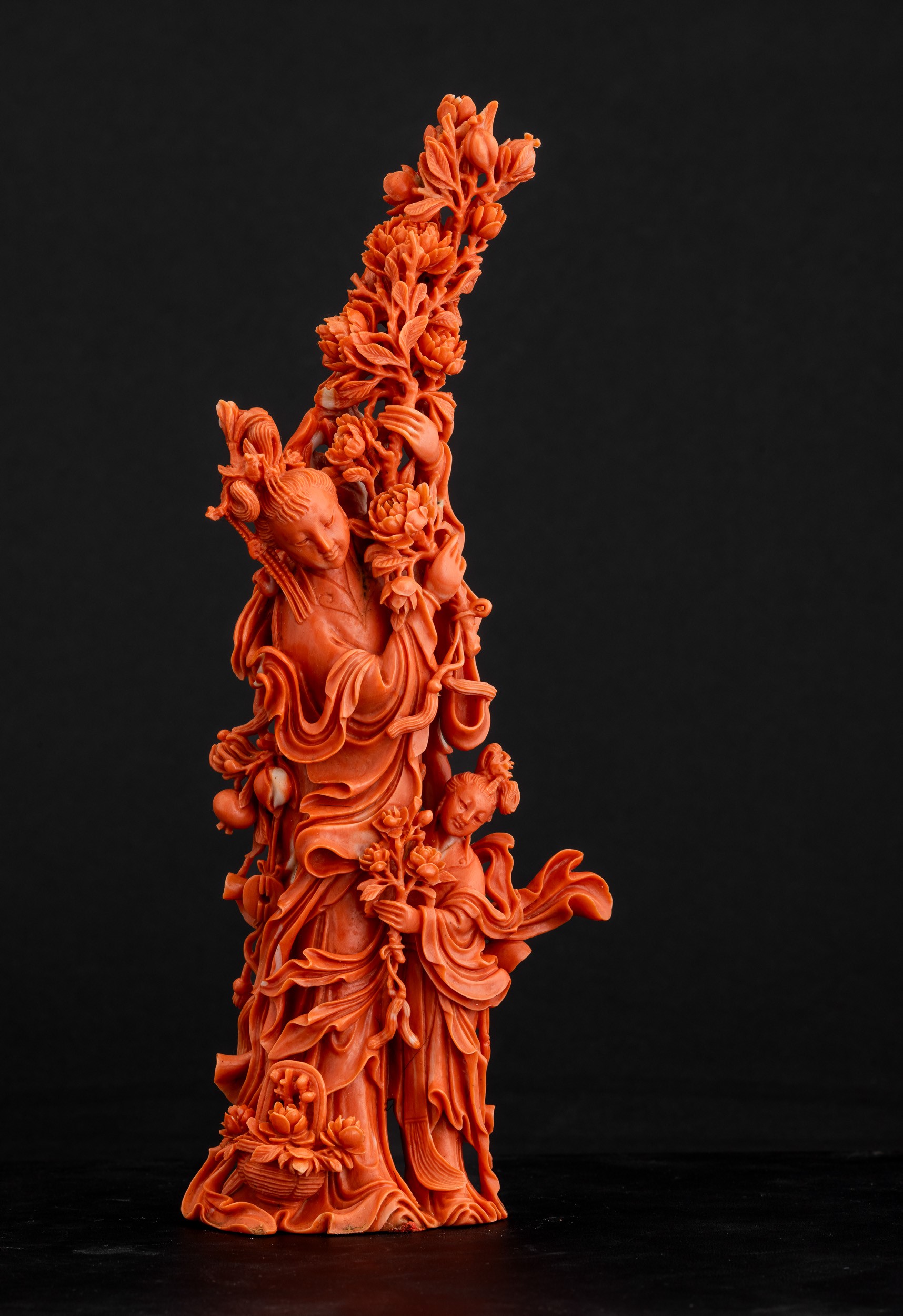 Cina, Dinastia Qing, Figura di Guanyin in corallo rosso con fiori tra le mani e fanciulla scolpit...