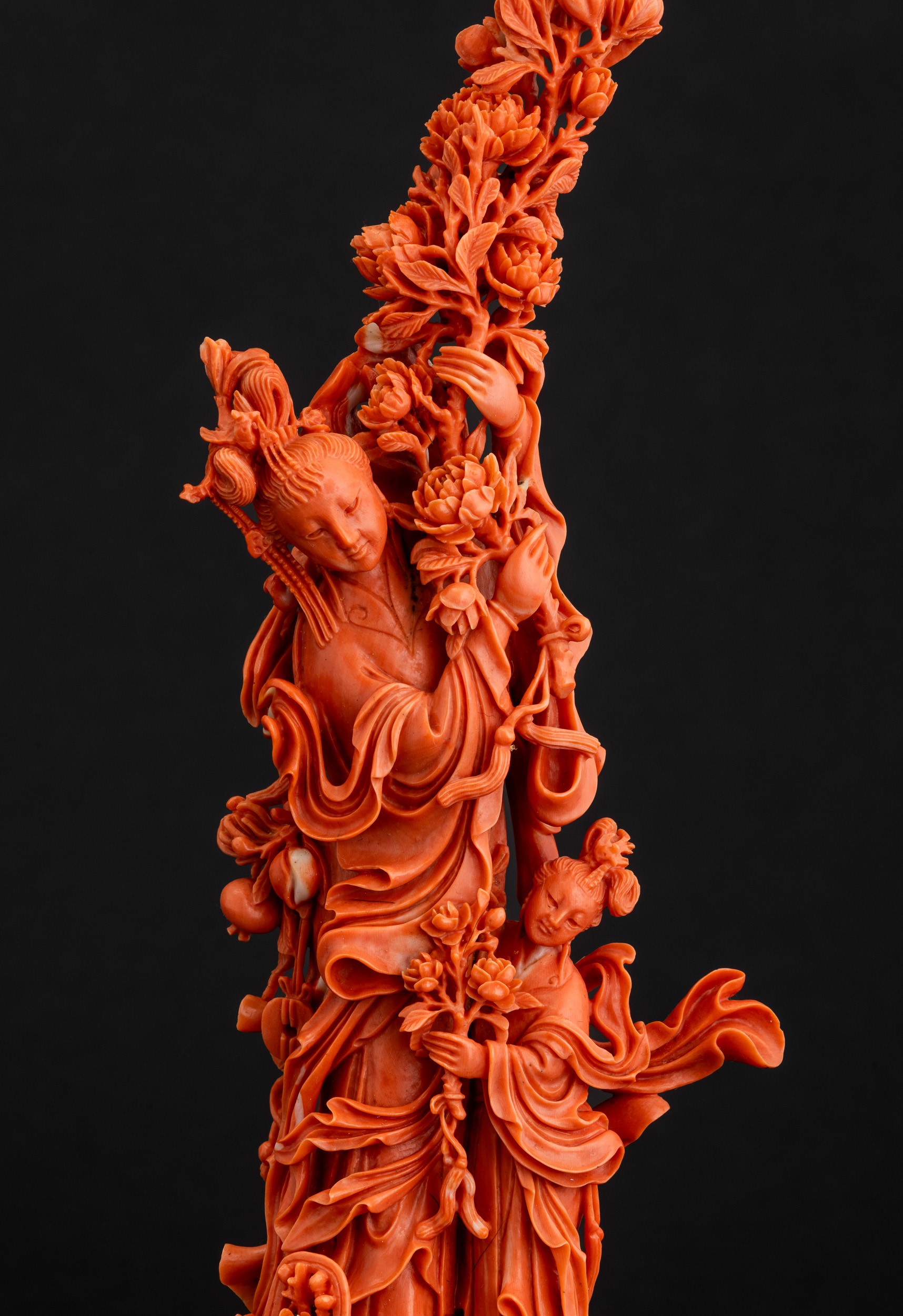Cina, Dinastia Qing, Figura di Guanyin in corallo rosso con fiori tra le mani e fanciulla scolpit...