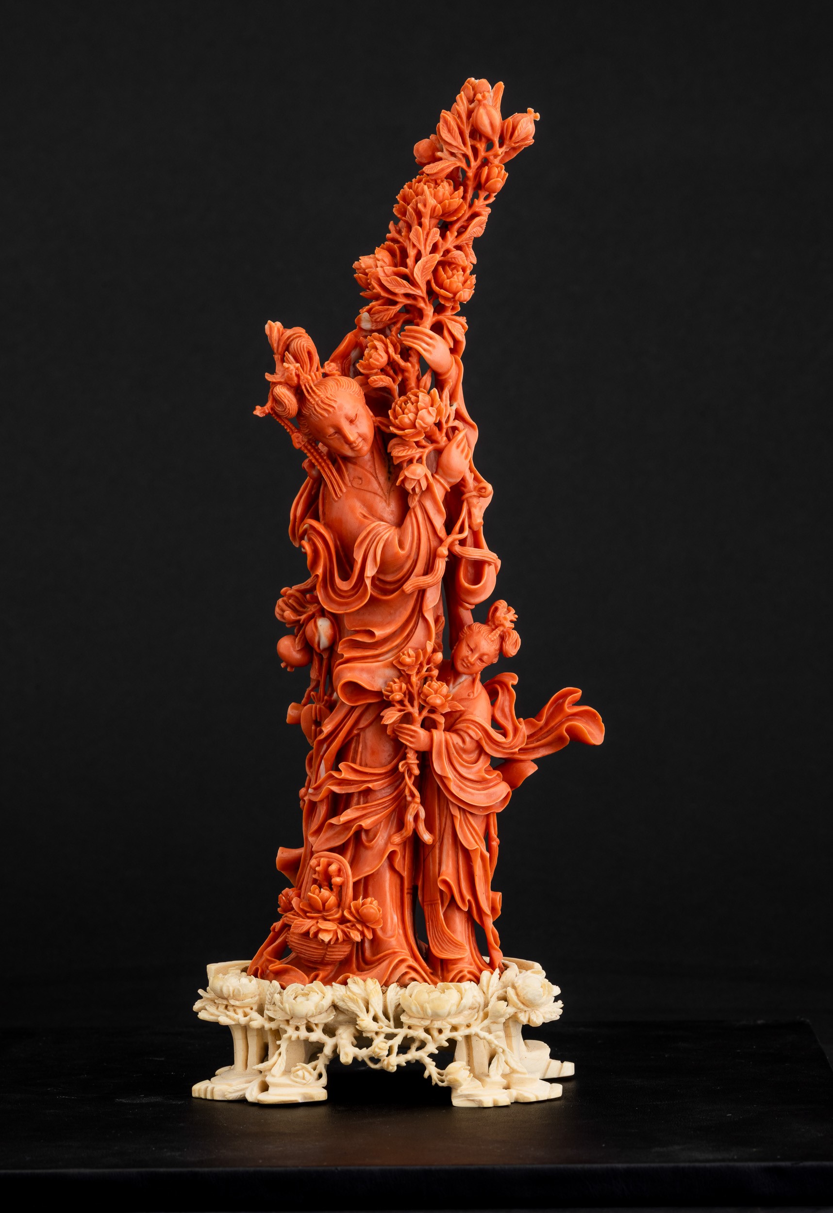 Cina, Dinastia Qing, Figura di Guanyin in corallo rosso con fiori tra le mani e fanciulla scolpit...
