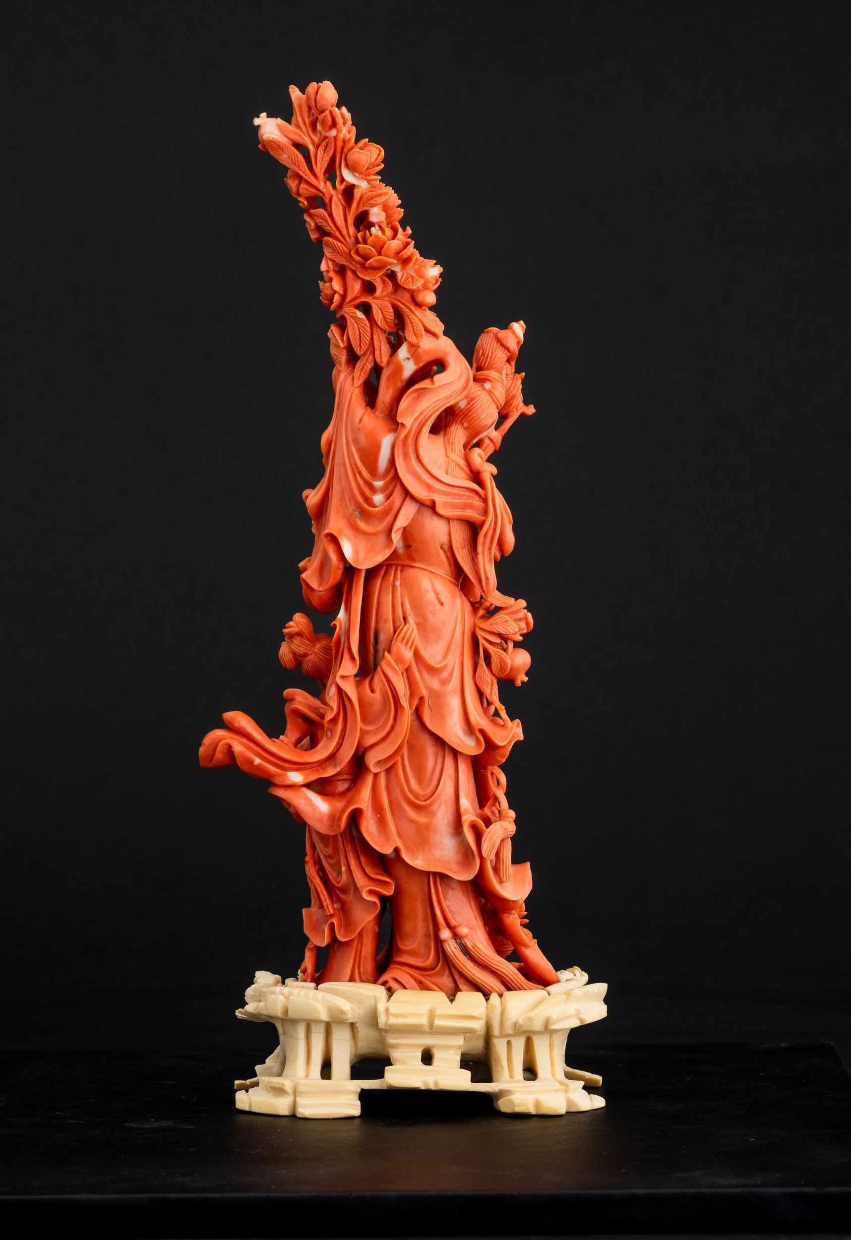 Cina, Dinastia Qing, Figura di Guanyin in corallo rosso con fiori tra le mani e fanciulla scolpit...