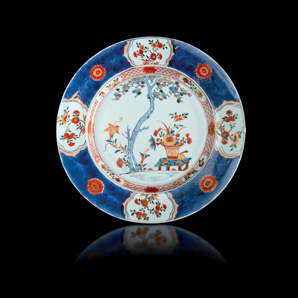 Piatto in porcellana Imari a soggetto paesaggistico e motivi floreali, Cina, Dinastia Qing, epoca Yongzheng (1723-1735)