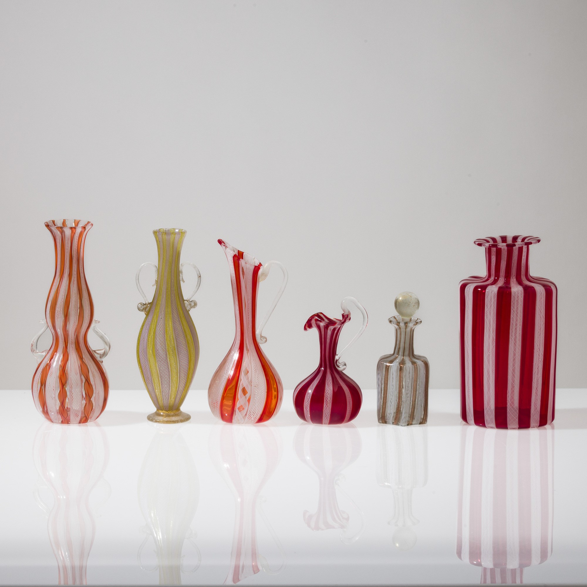 Murano, Collezione di dodici vasi in vetro soffiato con decorazione zanfirico e a reticello (XX s...