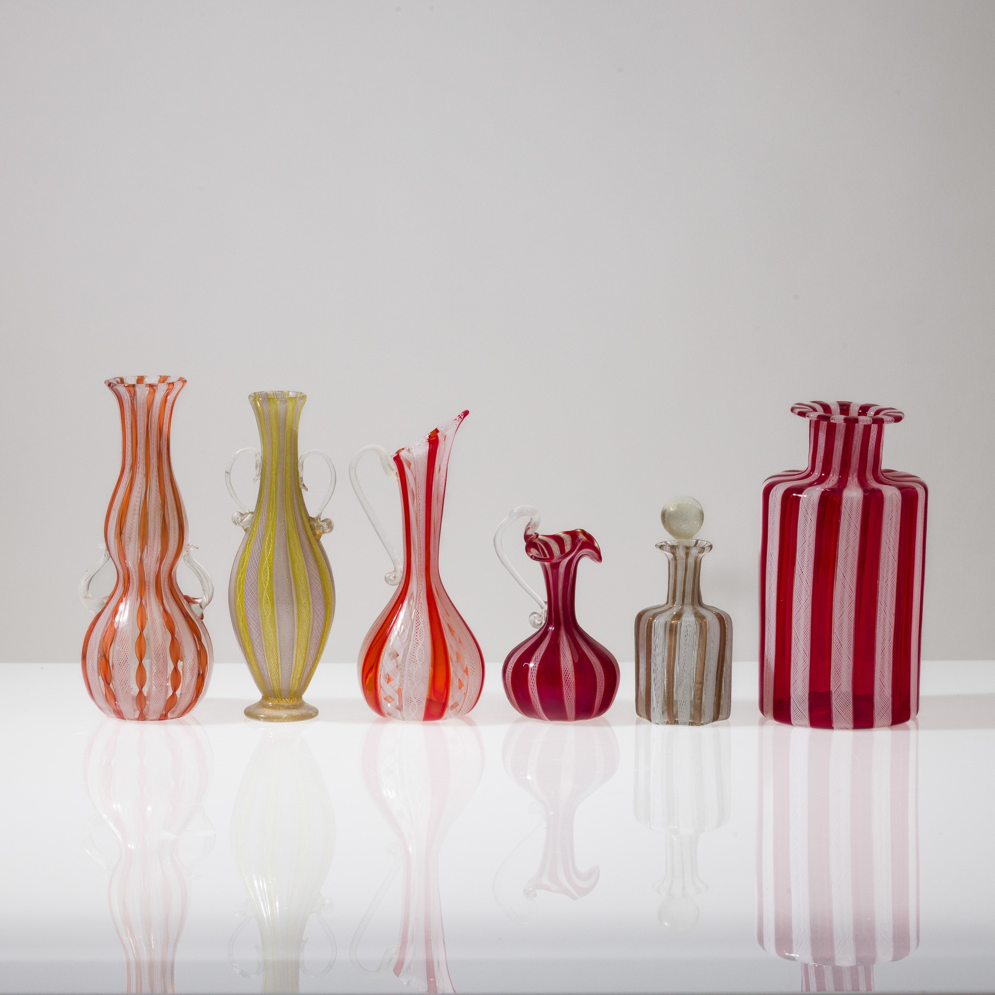 Murano, Collezione di dodici vasi in vetro soffiato con decorazione zanfirico e a reticello (XX s...
