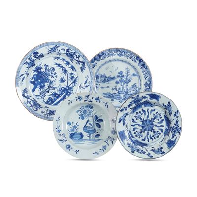 Cina (Dinastia Qing), Quattro piatti in porcellana bianca e blu con paesaggio e decorazioni veget...